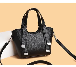 Détail du sac à main noir en cuir grainé avec des finitions métalliques argentées