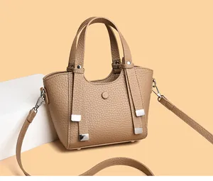 Détail du sac à main en cuir grainé kaki avec ferrures argentées et profil latéral