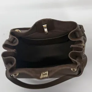 Brown leather bucket bag with drawstring design and spacious interior view
