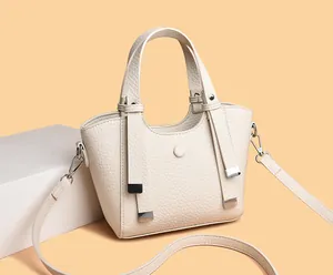 Vue détaillée du sac à main en cuir grainé crème avec doubles poignées et attaches métal
