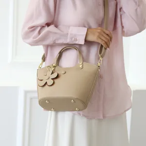 Elegant beige bucket bag in lychee pattern leather with floral charm for women