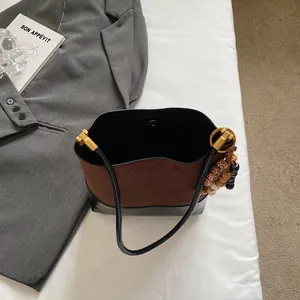 Chic vintage brown suede and black leather patchwork tote bag with gold metal clasp