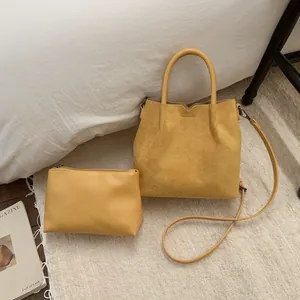 Détail du sac cabas jaune en daim avec pochette zippée assortie et bandoulière fine