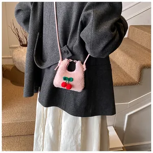 Detailansicht der Mini-Plüschtasche mit Kirschdekor auf einem Wintermantel