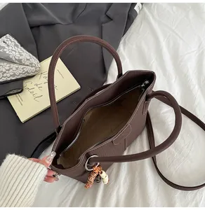 Detail der Innenseite einer kaffeebraunen Kunstledertasche mit vertikalen Streifen und Quaste