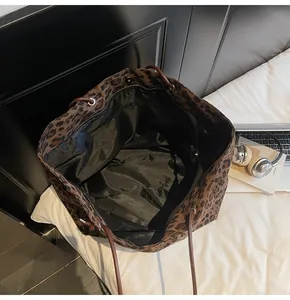 Detailed internal view of large leopard print tote bag with black lining and zip pocket