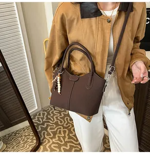 Braune Beuteltasche mit vertikalen Streifen an einem Modell für einen schicken Look