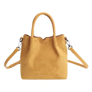 Sac seau en daim jaune moutarde avec coupe en V minimaliste et poignées en cuir lisse