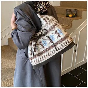Dettaglio borsa tote retrò in peluche con stampa floreale blu e fiocco in pelle