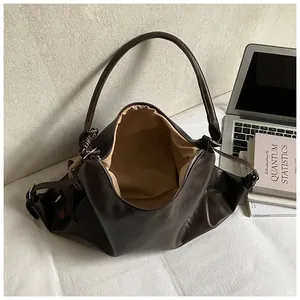 Vue détaillée du sac cabas en cuir marron foncé avec texture souple et fermeture éclair