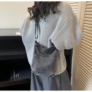 Détails du sac seau en denim gris vintage avec poches frontales et bandoulière