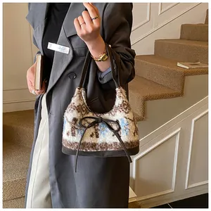 Dettaglio della borsa in peluche con motivo jacquard vintage e manici in pelle