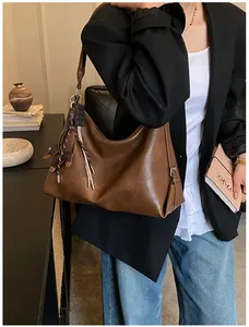 Sac à bandoulière marron rétro en cuir souple avec pendentif décoratif à franges