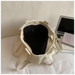 Minimalistische beige Tragetasche mit geräumigem Innenraum, schwarzem Futter und Goldbeschlägen