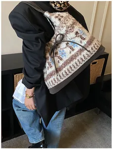 Dettaglio della borsa tote in peluche con motivi floreali blu e dettaglio fiocco marrone