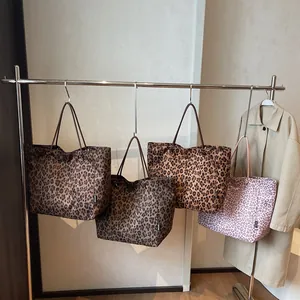 Large leopard print tote bags in four colors hanging on a minimalist display stand