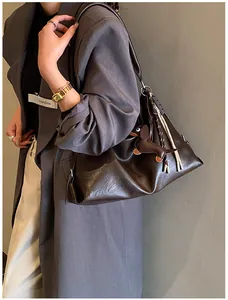Détail du sac cabas en cuir marron foncé souple avec breloque teckel sur la bandoulière robuste