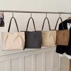 Minimalist canvas tote bag with pleated design and leather handles in four colors