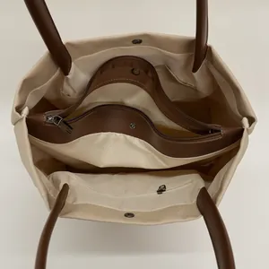Large capacity canvas tote bag with leather trim and multiple interior compartments