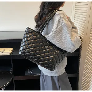 Detail of black quilted tote bag with diamond stitching on glossy nylon fabric
