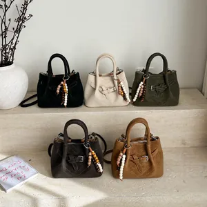 Minimalist crossbody bags in five colors featuring V-stitching and beaded charms