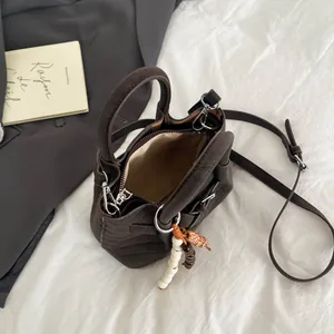 Minimalist dark brown crossbody handbag with beaded tassel and cylinder handle