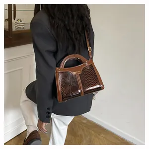 Brown faux leather crossbody bag with snake skin texture shown on a female model