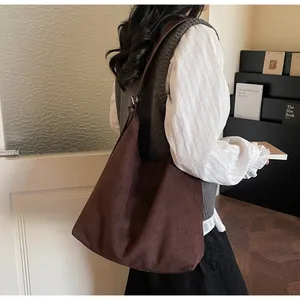 Detailed texture of dark brown suede tote bag showing soft matte finish and large capacity