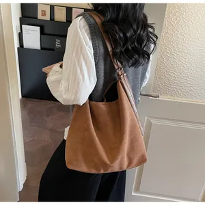 Detailed side view of caramel faux suede shoulder bag showing texture and adjustable strap
