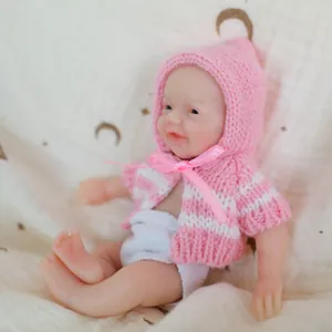 6 inch realistic soft silicone baby doll wearing a pink and white knitted hoodie