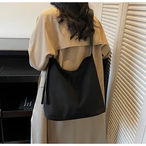 Black matte hobo bucket bag in a large capacity minimalist shoulder style on a model