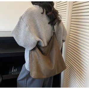Brown faux suede shoulder bag with minimalist design shown in a side-view lifestyle shot