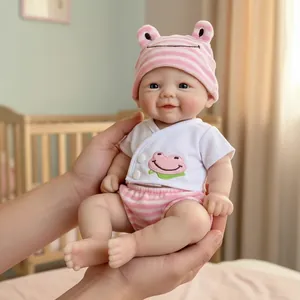 12-inch lifelike baby doll with pink frog hat and striped outfit held in hands
