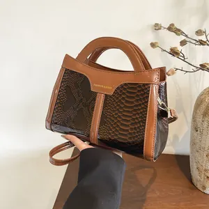 Detailed close-up of brown snakeskin texture handbag with gold Fashion & Bags lettering