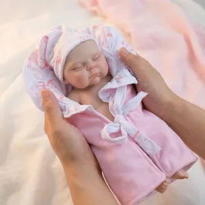 Lifelike 12-inch sleeping reborn baby doll in pink floral hat and lace-trimmed outfit