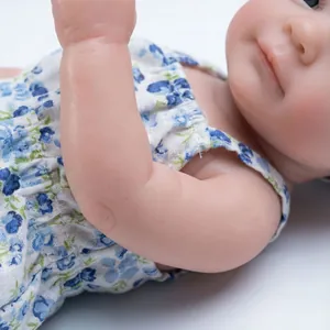 Realistic 12 inch reborn baby doll with blue floral outfit on a white background