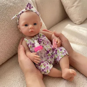 Lifelike 12-inch reborn baby doll in purple floral jumpsuit with bottle accessories