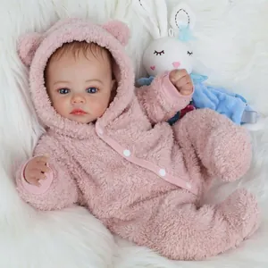 Realistic 49cm reborn baby doll with blue eyes in a pink bear ear romper and plush bunny