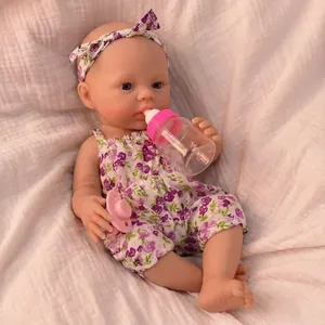 Realistic 12 inch newborn doll in purple floral romper with headband and feeding bottle