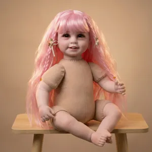 Realistic reborn doll with long pink hair and bow accessory in a natural sitting pose