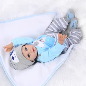 Realistic reborn baby doll in blue cartoon outfit with bottle and soft white blanket