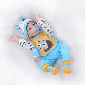 Bambola Reborn realistica con vestiti blu, bavaglino con rinoceronte e accessori
