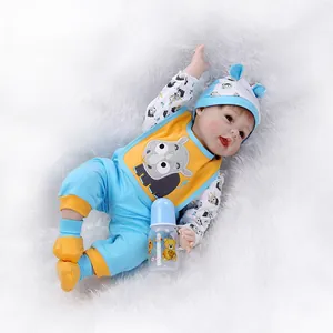 Bambola Reborn realistica in abito blu e giallo con bavaglino a rinoceronte e biberon