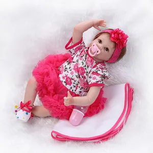 Realistische Reborn Babypuppe in rosa Blumenkleid auf weißem Plüschteppich liegend
