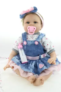 Detailed view of reborn baby doll in denim tutu dress with pacifier and bottle accessories