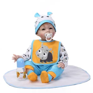 Bambola reborn realistica in abito blu con rinoceronte con ciuccio e biberon su cuscino