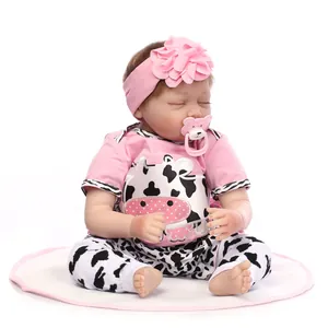 Realistic sleeping reborn baby doll with pink headband, pacifier and cow print outfit