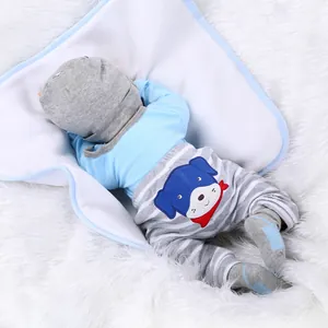 Realistic newborn baby doll in blue puppy outfit lying on a soft white faux fur rug