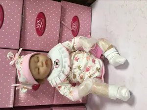 Detailed view of a sleeping reborn baby doll in floral outfit with NPK collection branding