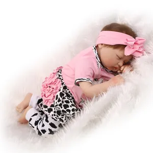 Sleeping realistic reborn baby doll in pink floral headband and cow print outfit